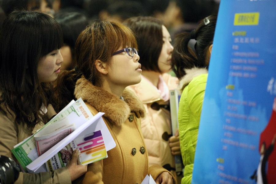 Job seekers read employment information at a job fair in Nanjing, capital of east China's Jiangsu Province, March 2, 2013. More than 20,000 job opportunities were offered at the job fair. (Xinhua/Wang Xin) 