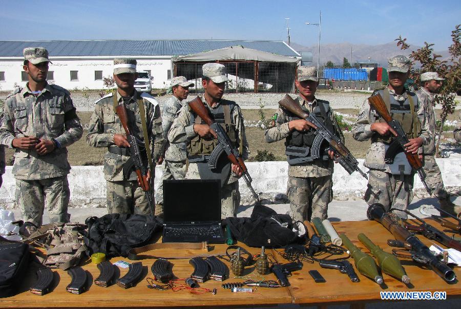 Afghan border police stand guard while Taliban's ammunition is presented to the media in Nangarhar province, eastern Afghanistan, on March 2, 2013. Afghan border police captured seven Taliban fighters with their ammunition during a operation in Nangarhar province on Saturday. (Xinhua/Tahir Safi) 