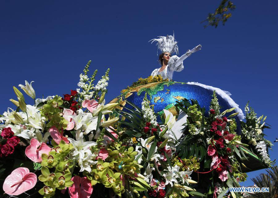 A performer throws flowers to visitors during the flowers parade of the 129th annual Nice Carnival parade, in Nice, southern France, March 2, 2013. (Xinhua/Gao Jing) 