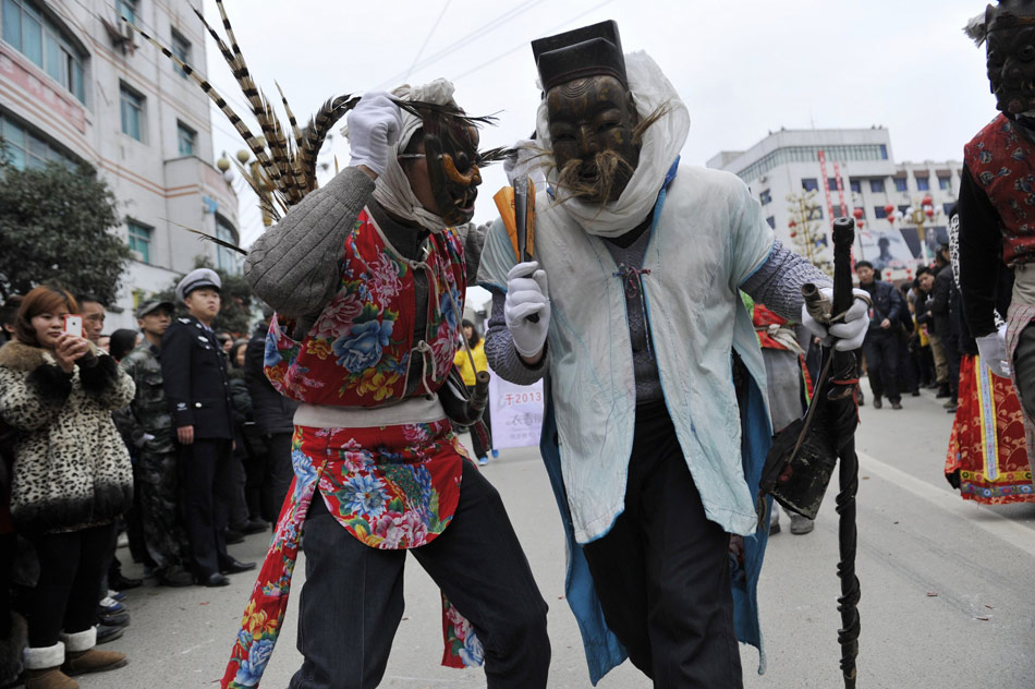 Tujia people perform Nuo drama in the street for celebration of the Lantern Festival in Dejiang county of Guizhou on Feb. 23, 2013. (Xinhua/Ou Dongqu)