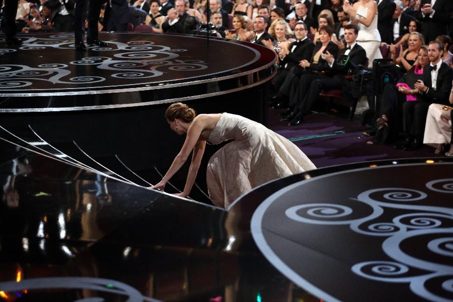 Actress Jennifer Lawrence falls as she walks up the steps to accept the award for best actress for her role in "Silver Linings Playbook" at the 85th Academy Awards in Hollywood, California February 24, 2013. (Xinhua/AP Photo)