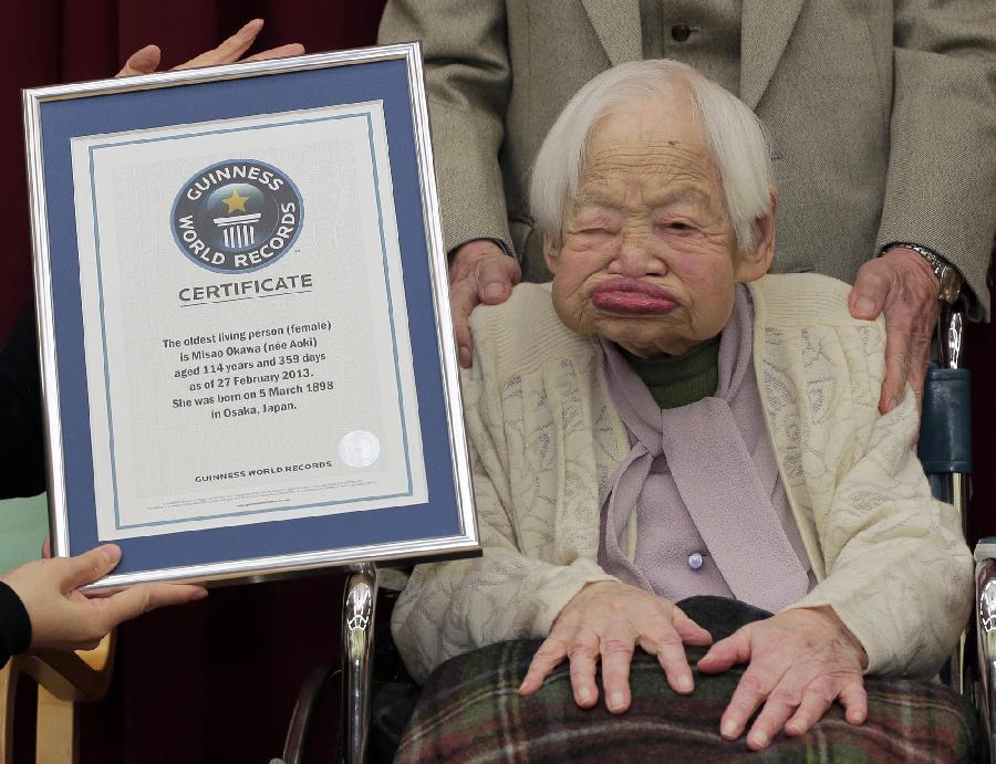 Misao Okawa (R) receives a certification from an official of Guinness World Records in Osaka, western Japan, in this photo taken by Kyodo February 27, 2013.  (Xinhua/AP Photo)