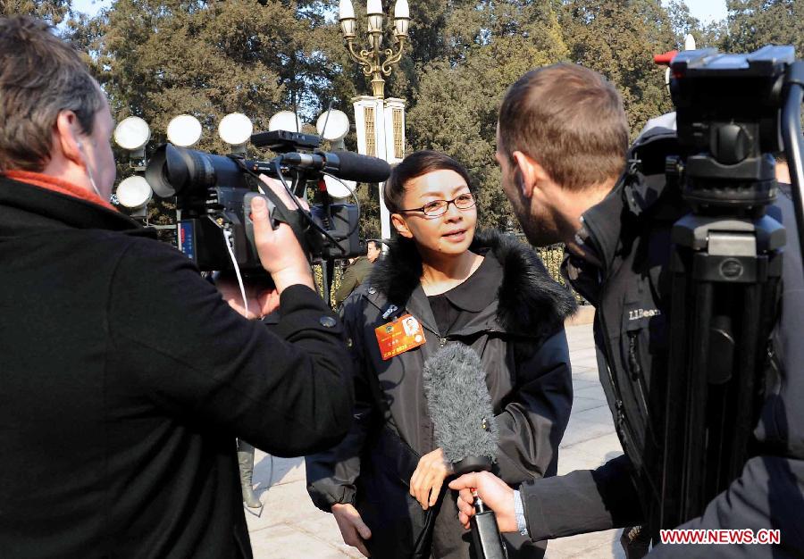 Song Dandan (C), a member of the 12th National Committee of the Chinese People's Political Consultative Conference (CPPCC), receives an interview by foreign journalists outside the Great Hall of the People in Beijing, capital of China, March 3, 2013. The first session of the 12th CPPCC National Committee opened in Beijing on March 3. (Xinhua/Wang Song)