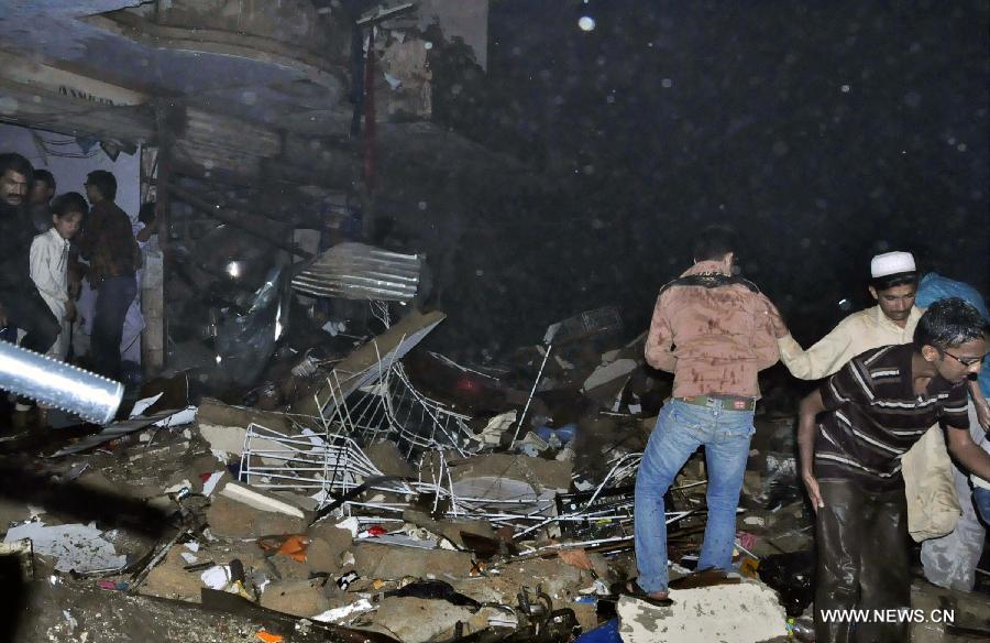 Residents work at the twin blasts site in southern Pakistani port city of Karachi on March 3, 2013. At least 40 people were killed and over 135 others injured when twin blasts hit a residential area in Pakistan's southern port city of Karachi on Sunday night, local health official said. (Xinhua/Masroor)