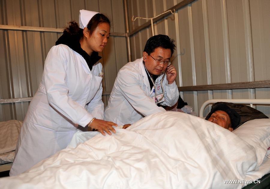Doctors treat an injured man at a clinic after a 5.5-magnitude earthquake in Eryuan County of Dali Bai Autonomous Prefecture, southwest China's Yunnan Province, on March 3, 2013. The number of people confirmed injured by a 5.5-magnitude earthquake that hit southwest China's Yunnan Province on Sunday afternoon has risen to 30, local authorities have said. (Xinhua/Lin Yiguang) 