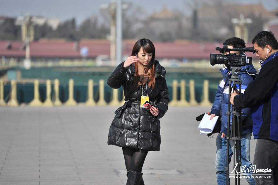 A beautiful journalist reports the first session of the 12th CPPCC National Committee in front of the Great Hall of the People in Beijing on March 3, 2013. (People's Daily Online/Yu Kai)