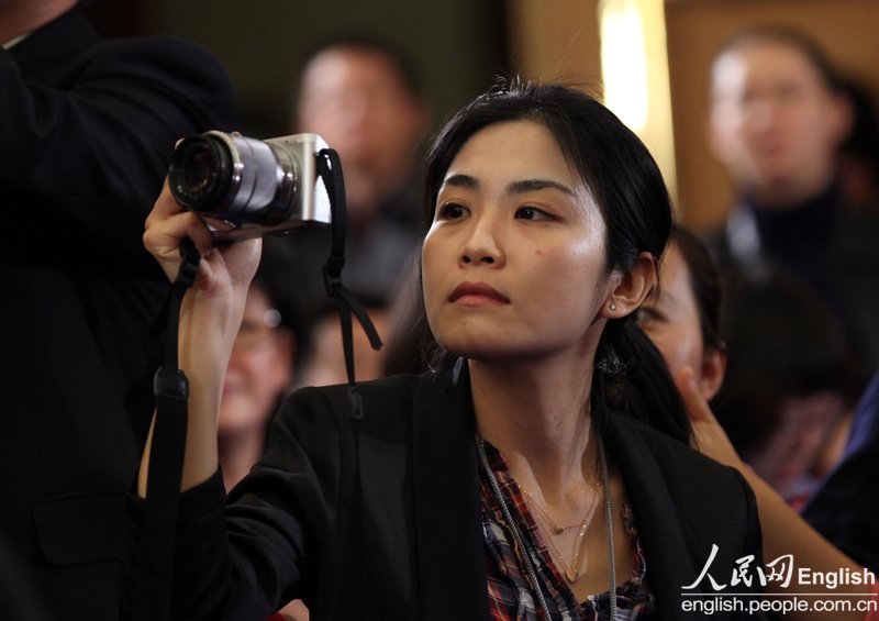 A journalist takes photo at a press conference of the first session of the 12th CPPCC National Committee.(Photo/People's Daily Online)