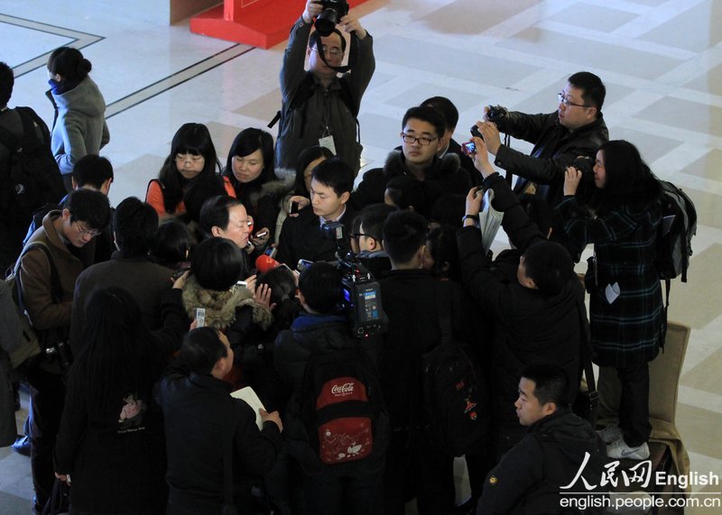 A group of journalists interview a CPPCC member in Beijing Convention Centre. (Photo/People's Daily Online)