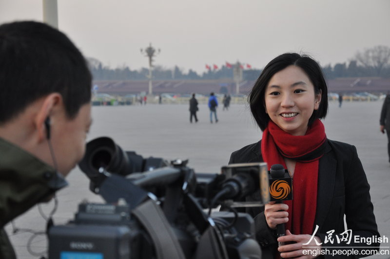 A journalist reports at Tiananmen Square. (Photo/People's Daily Online)