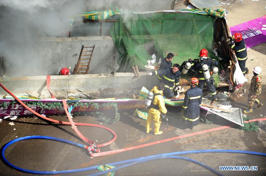Firefighters work at the accident site after an explosion hit an underground passage in front of a shopping mall in Shenyang, capital of northeast China's Liaoning Province, March 4, 2013. It was not immediately known if there are any casualties. The shock wave of the blast at about 9 a.m. on Monday could be felt one kilometer away, local residents said. (Xinhua/Pan Yulong)