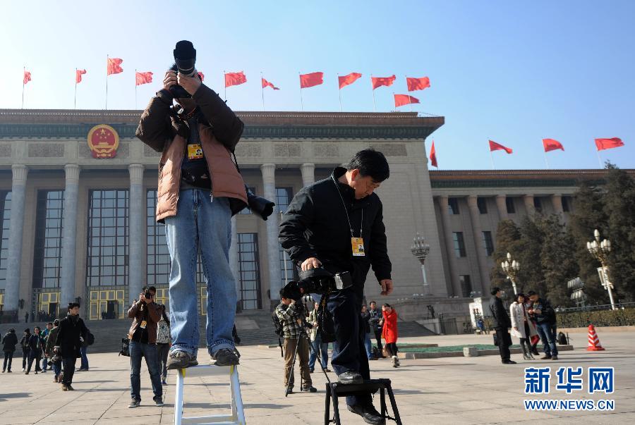 Journalists take pictures in front of the Great Hall of the People. (Xinhua/Yang Qing)