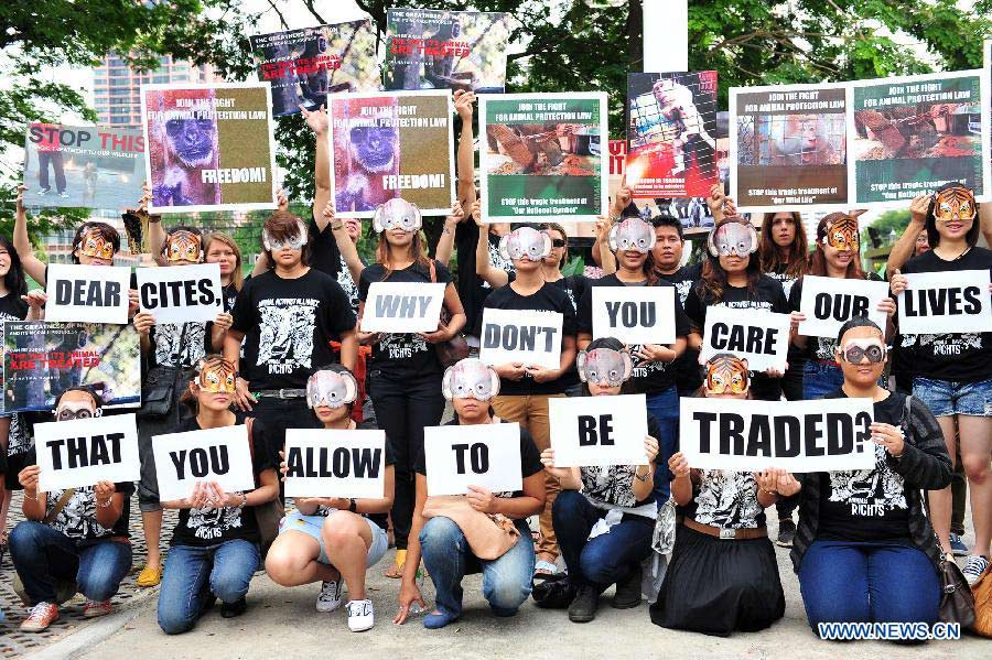 Activists holding placards call for a stop of animal trade at Queen Sirikit National Convention Center in Bangkok, Thailand, March 4, 2013. Curbing the trade in "blood ivory" is at the top of the agenda during a Convention on the International Trade in Endangered Species of Wild Fauna and Flora (CITES), which opens in Thailand on Sunday. (Xinhua/Rachen Sageamsak) 