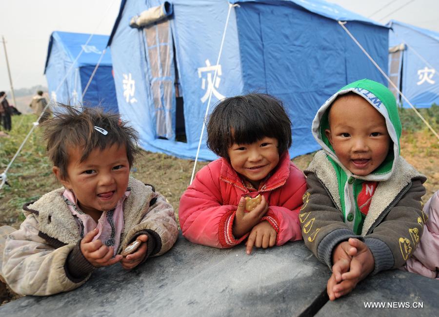 Children play near the relief tents at Qiandian Village of Liantie Township in Eryuan County of Dali Bai Autonomous Prefecture, southwest China's Yunnan Province, March 4, 2013. A 5.5-magnitude earthquake hit Eryuan County on March 3. Thirty people have been confirmed injured, while some 21,000 people have been evacuated. (Xinhua/Lin Yiguang) 