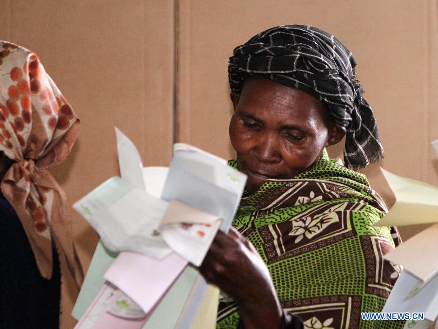 A voter looks at her ballots at a polling station in Nairobi, Kenya, March 4, 2013. A total of 14.3 million Kenyan voters lined up to cast their ballots Monday morning to choose the country's next president, the first after disputed presidential elections tally stirred up violence five years ago. (Xinhua/Meng Chenguang) 