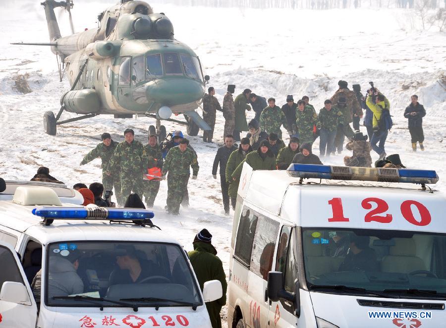 Rescued people are sent to ambulances near the Songhuajiang River, northeast China's Jilin Province, March 4, 2013. Nine people were evacuated to safety by a helicopter after three ferries carrying nine passengers were stranded for more than 28 hours in the Songhua River on Monday. (Xinhua) 