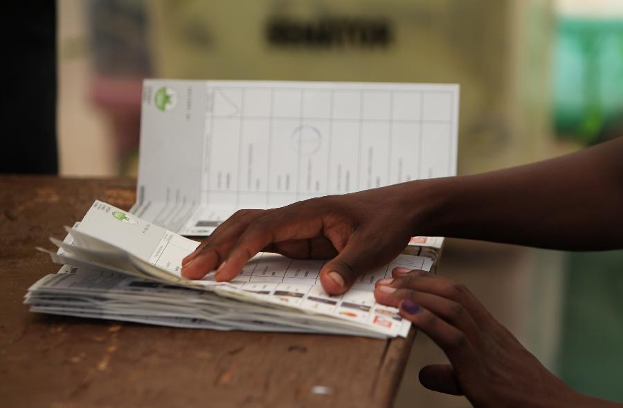 A staff worker presses ballot papers with hands at a counting station in Nairobi, Kenya, March 4, 2013. Millions of Kenyans turned up early Monday to vote in the historic general elections after independence and in the first national exercise under new constitution after the a disputed polls in 2007. According to the constitution, Kenya's Independent Electoral and Boundaries Commission (IEBC) will have seven days to officially announce the results, but the country's next president is expected to be known by Monday evening or Tuesday. (Xinhua/Meng Chenguang) 
