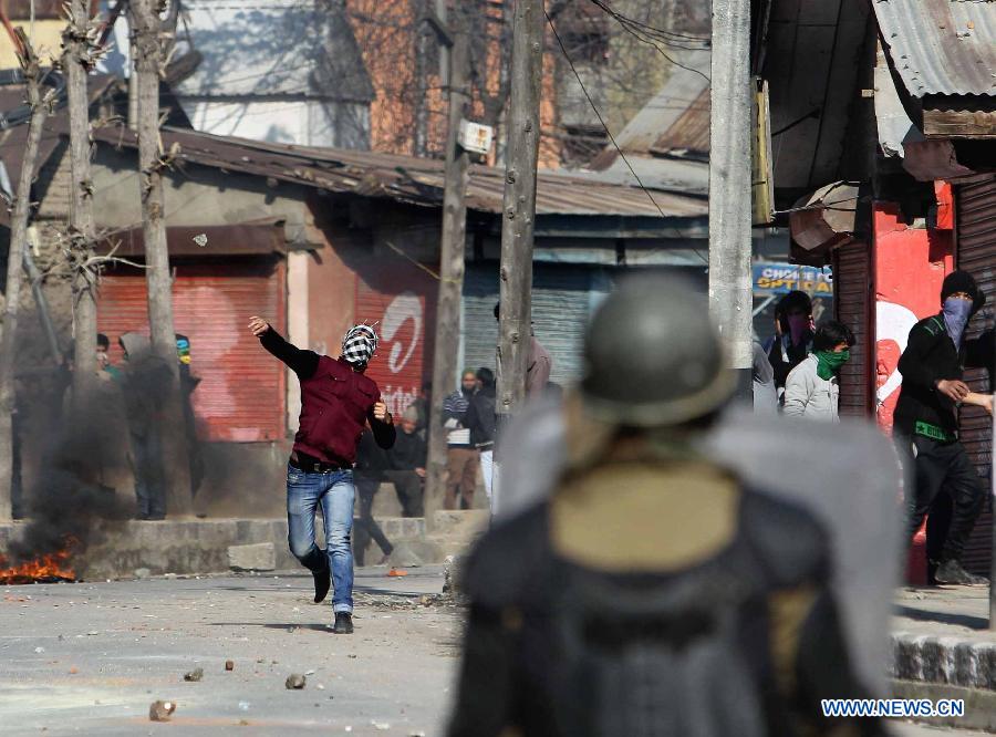 A Kashmiri protester throws stones at Indian paramilitary soldiers and police during a protest in Srinagar, summer capital of Indian-controlled Kashmir, March 4, 2013. Tension gripped Muslim majority areas of Indian-controlled Kashmir on Monday following the death of a Kashmiri student in Indian state of Andhra Pradesh. (Xinhua/Javed Dar) 