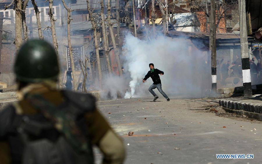 A Kashmiri protester confronts with Indian paramilitary soldiers and police during a protest in Srinagar, summer capital of Indian-controlled Kashmir, March 4, 2013. Tension gripped Muslim majority areas of Indian-controlled Kashmir on Monday following the death of a Kashmiri student in Indian state of Andhra Pradesh. (Xinhua/Javed Dar) 
