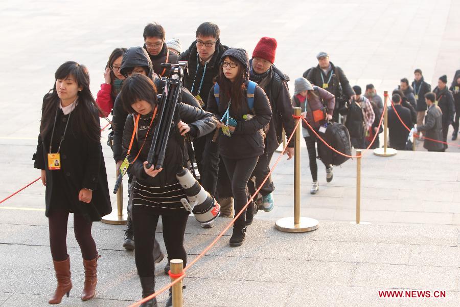 Journalists enter into the Great Hall of the People in Beijing, capital of China, March 5, 2013. The first session of the 12th National People's Congress (NPC) will open here on March 5. (Xinhua/Xing Guangli)