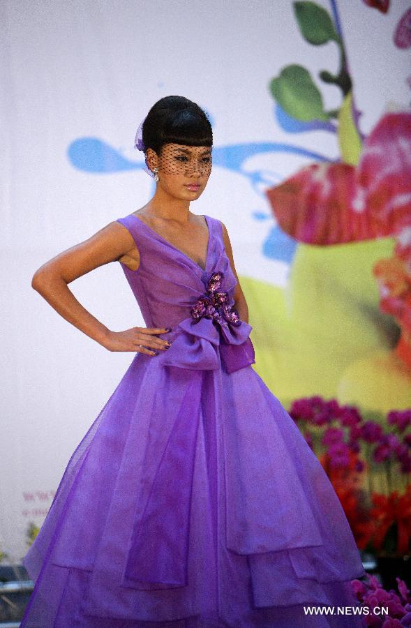 A model presents a creation themed with orchid during a press conference for the upcoming Orchid Show in Taipei, southeast China's Taiwan, March 4, 2013. The 2013 Taiwan International Orchid Show will be held in Tainan City from March 9 to 18. (Xinhua/Xie Xiudong)