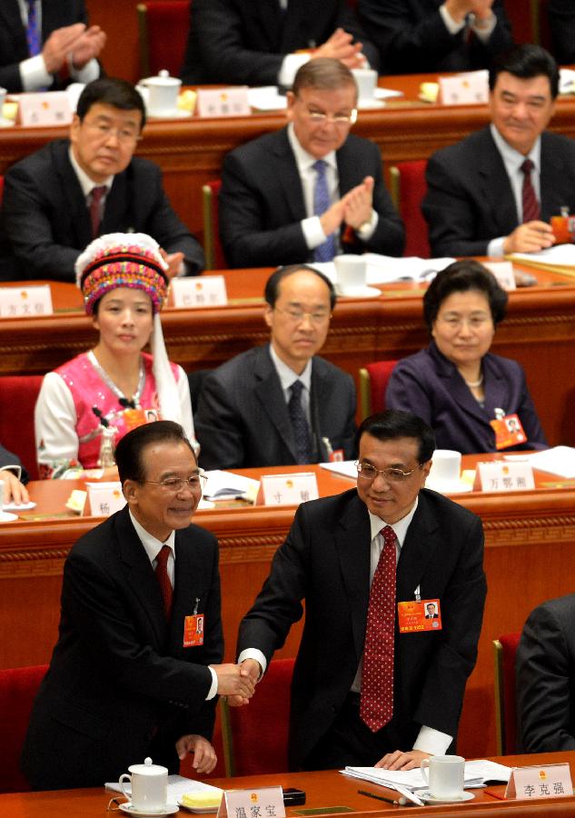 Wen Jiabao (L bottom) shakes hands with Li Keqiang after he delivered the government work report during the opening meeting of the first session of the 12th National People's Congress (NPC) at the Great Hall of the People in Beijing, capital of China, March 5, 2013. The first session of the 12th NPC opened in Beijing on March 5. (Xinhua/Wang Song)