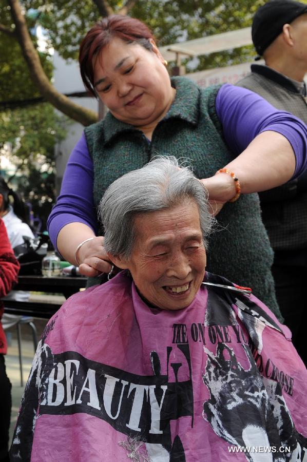 An old woman receives the service of free haircut at a community in Hangzhou City, capital of east China's Zhejiang Province, March 5, 2013. Various activities were held across the country to learn from Lei Feng, a young Chinese soldier in the 1960s who is known for devoting almost all of his spare time and money to selflessly help the needy. Lei died after being hit by a falling pole while helping a fellow soldier direct a truck on Aug. 15, 1962. A year later, late Chinese leader Chairman Mao Zedong called on the nation to follow Lei's example, and March 5 of every year is designated as "Lei Feng Day." (Xinhua/Ju Huanzong)