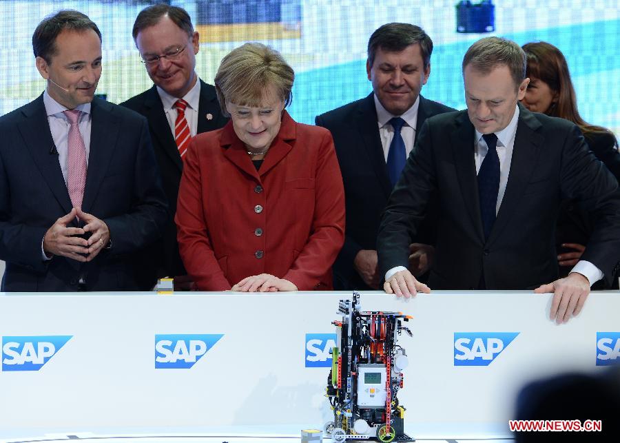 Polish Prime Minister Donald Tusk (2nd R) and German Chancellor Angela Merkel (3rd L) watch a robot at the showcase of SAP at the CeBIT tech fair in Hanover, Germany, March 5, 2013. CeBIT, the world's leading exhibition in the communication and information technology industry, opened Monday evening in Hanover, Germany. (Xinhua/Ma Ning) 