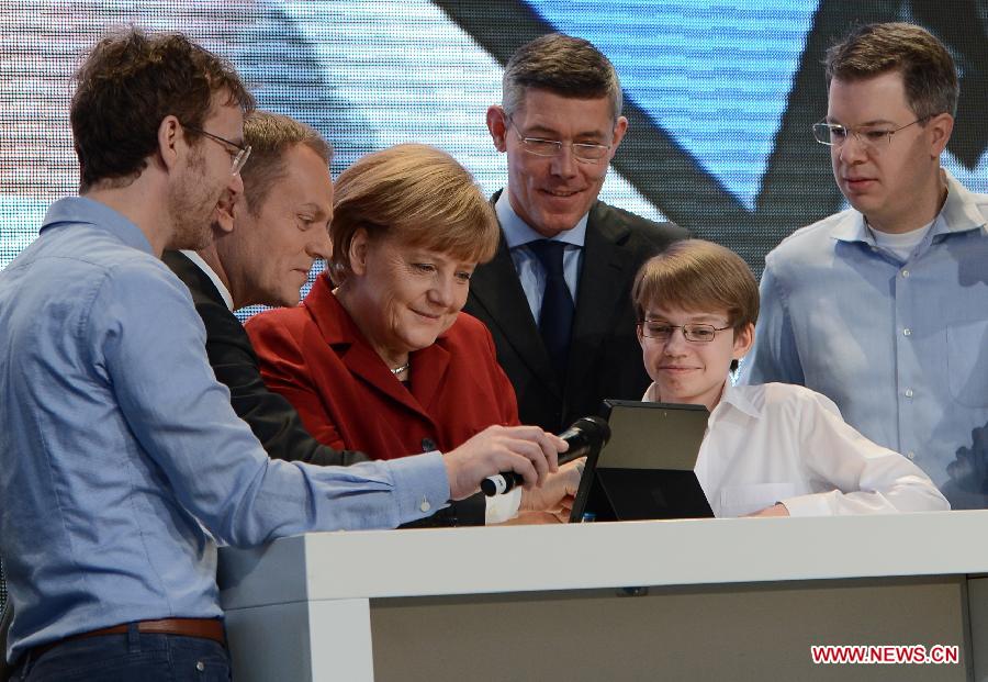 Polish Prime Minister Donald Tusk (2nd L) and German Chancellor Angela Merkel (3rd L) visit the showcase of Microsoft at the CeBIT tech fair in Hanover, Germany, March 5, 2013. CeBIT, the world's leading exhibition in the communication and information technology industry, opened Monday evening in Hanover, Germany. (Xinhua/Ma Ning) 