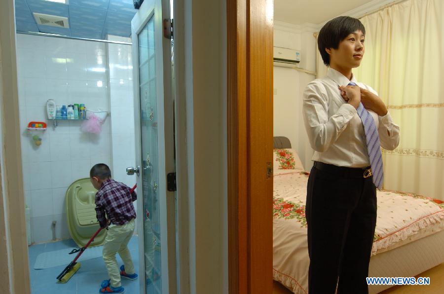 Cao Shuang, an airborne security guard of China South Air, dresses for work in Sanya, southernmost China's island province of Hainan, March 4, 2013. (Xinhua/Xu Qintao) 