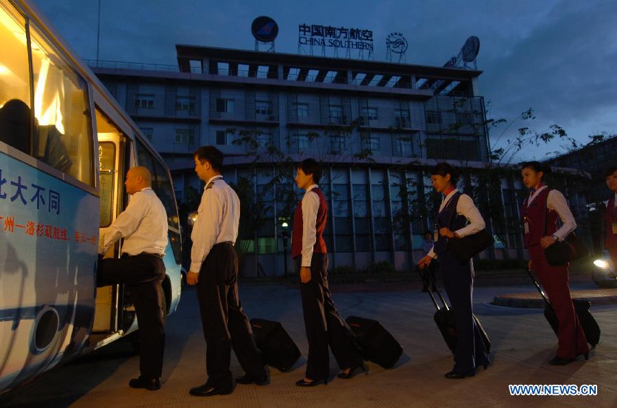 Cao Shuang (C), an airborne security guard of China South Air, boards a bus with aircrew members for the Phoenix International Airport in Sanya, southernmost China's island province of Hainan, March 4, 2013. (Xinhua/Xu Qintao) 