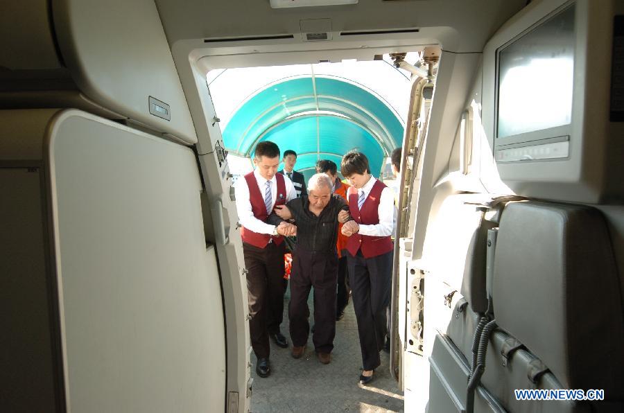 Cao Shuang (1st R), an airborne security guard of China South Air, helps an elderly passenger board an airliner at the Phoenix International Airport in Sanya, southernmost China's island province of Hainan, March 4, 2013. (Xinhua/Xu Qintao) 