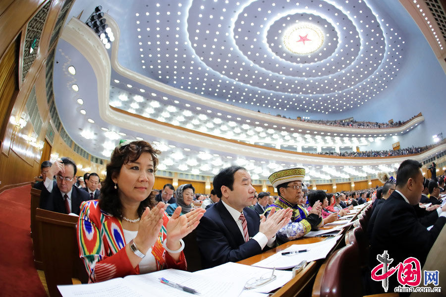 A female ethnic minority deputy wearing a traditional ethnic minority costume carefully listens the government work report during the opening meeting of the first session of the 12th National People's Congress (NPC) at the Great Hall of the People in Beijing, capital of China, March 5, 2013. (China Pictorial/Xu Xun)