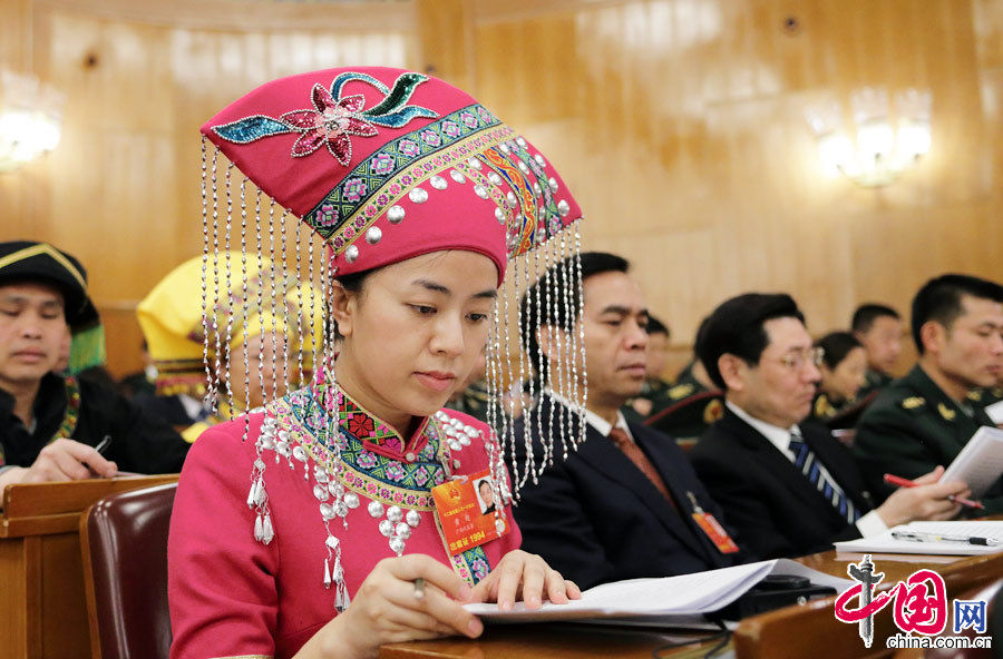 Huang Chao, a female ethnic minority deputy from Guangxi Zhuang autonomous region carefully listens the government work report during the opening meeting of the first session of the 12th National People's Congress (NPC) at the Great Hall of the People in Beijing, capital of China, March 5, 2013. (China Pictorial/Xu Xun)