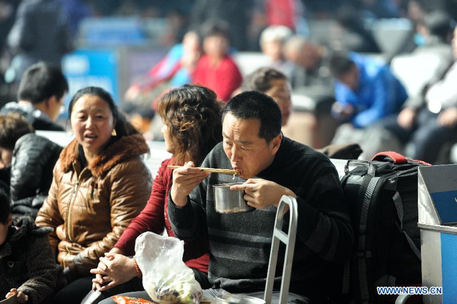 A passenger eats instant noodles in a waiting hall at the railway station in Harbin, capital of northeast China's Heilongjiang Province, March 6, 2013. The 40-day Spring Festival travel rush, started on Jan. 26 this year, came to the last day on Wednesday. The Spring Festival, which falls on Feb. 10 this year, is traditionally the most important holiday of the Chinese people. It is a custom for families to reunite in the holiday, a factor that has led to massive seasonal travel rushes in recent years as more Chinese leave their hometowns to seek work elsewhere. (Xinhua/Wang Song)
