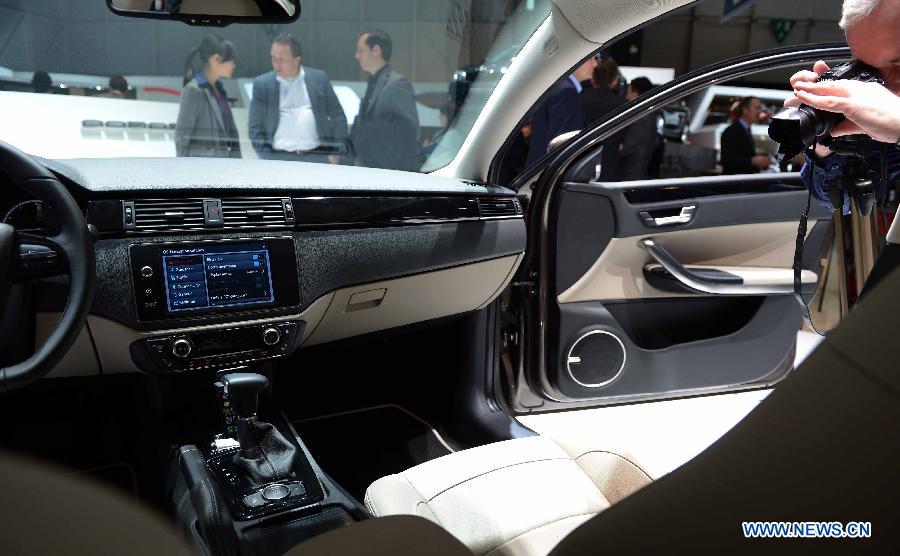 A visitor takes photos of the Qoros 3 sedan on the press day of the 83rd Geneva International Motor Show in Geneva, Switzerland, on March 6, 2013. (Xinhua/Wang Siwei)