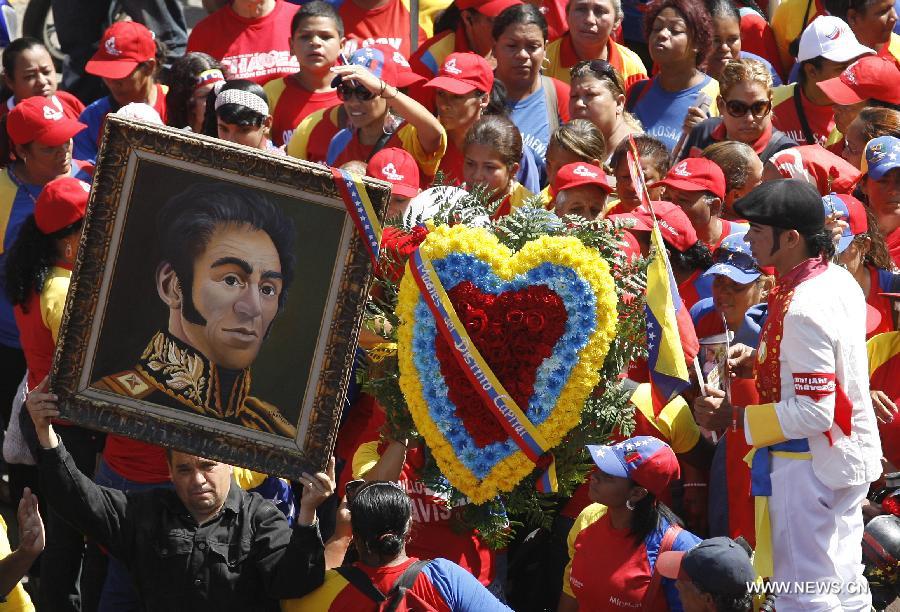 Residents participate in the funeral procession in honor of Venezuelan President Hugo Chavez on the streets of Caracas, capital of Venezuela, on March 6, 2013. On Tuesday afternoon, Venezuelan President, Hugo Chavez, died after fighting for almost two years with a cancer disease. The body of Chavez is moved from the health center to the Military Academy in southern Caracas, inside Tiuna's Fort. (Xinhua/Juan Carlos Hernandez)