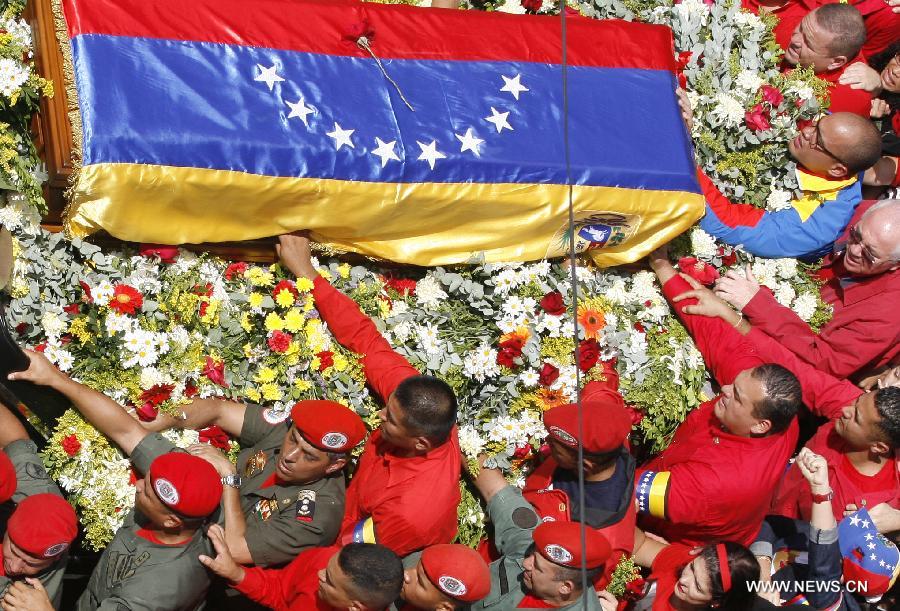 Members of the military escort Venezuelan National Guard hold a security fence during the funeral procession in honor of Venezuelan President Hugo Chavez on the streets of Caracas, capital of Venezuela, on March 6, 2013. On Tuesday afternoon, Venezuelan President, Hugo Chavez, died after fighting for almost two years with a cancer disease. The body of Chavez is moved from the health center to the Military Academy in southern Caracas, inside Tiuna's Fort. (Xinhua/Juan Carlos Hernandez)