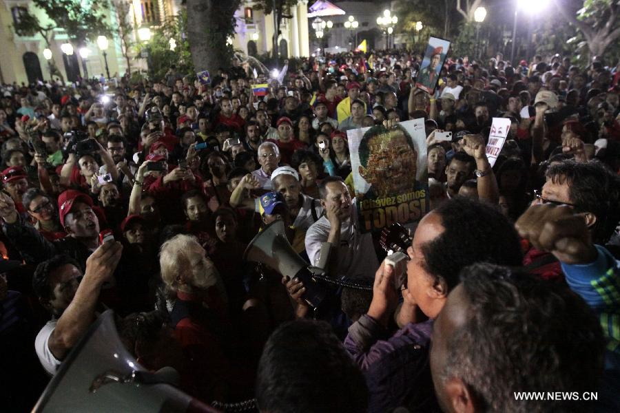 Residents participate in the funeral procession in honor of Venezuelan President Hugo Chavez on the streets of Caracas, capital of Venezuela, on March 6, 2013. On Tuesday afternoon, Venezuelan President, Hugo Chavez, died after fighting for almost two years with a cancer disease. The body of Chavez is moved from the health center to the Military Academy in southern Caracas, inside Tiuna's Fort. (Xinhua/David de la Paz)