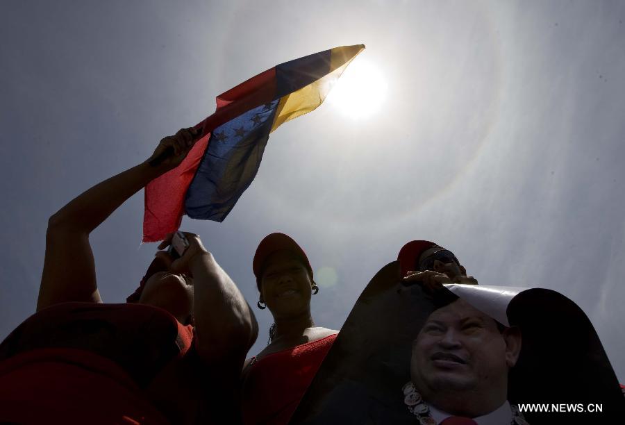 Residents participate in the funeral procession in honor of Venezuelan President Hugo Chavez on the streets of Caracas, capital of Venezuela, on March 6, 2013. On Tuesday afternoon, Venezuelan President, Hugo Chavez, died after fighting for almost two years with a cancer disease. The body of Chavez is moved from the health center to the Military Academy in southern Caracas, inside Tiuna's Fort. (Xinhua/David de la Paz)