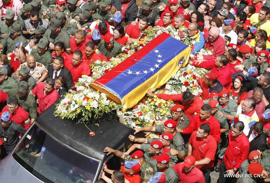 Members of the military escort Venezuelan National Guard hold a security fence during the funeral procession in honor of Venezuelan President Hugo Chavez on the streets of Caracas, capital of Venezuela, on March 6, 2013. On Tuesday afternoon, Venezuelan President, Hugo Chavez, died after fighting for almost two years with a cancer disease. The body of Chavez is moved from the health center to the Military Academy in southern Caracas, inside Tiuna's Fort. (Xinhua/Juan Carlos Hernandez)