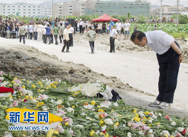 Wen Jiabao presents flowers and bows to mourn for victims in the train crash in Wenzhou, east China's Zhejiang Province on July 28, 2011. (Xinhua File Photo)