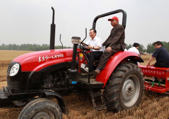 Wen Jiabao works in a corn field on a tractor in Xuchang County, central China's Henan Province on June 10, 2010. (Xinhua File Photo)