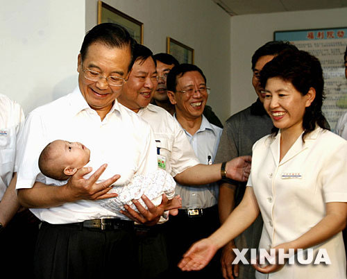 Wen Jiabao holds a baby at an orphanage in Daqing, northeast China's Heilongjiang Province on August 11, 2006. (Xinhua File Photo)