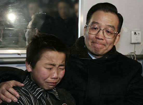 Wen Jiabao comforts a boy whose father died in a mine accident in northwest China's Shaanxi Province on January 2, 2005.(Xinhua File Photo)