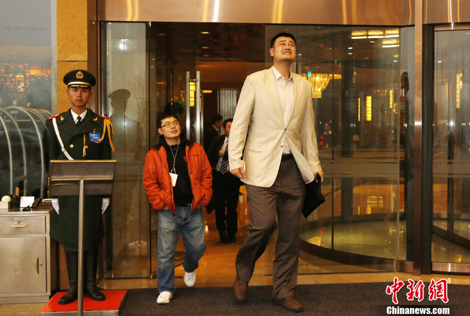 Yao Ming looks up and appears worried about the hazy weather when walking out of the hotel on the morning of Feb. 28 2013.