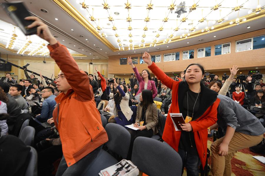 Journalists raise hands to ask questions at a press conference held by the first session of the 12th National Committee of the Chinese People's Political Consultative Conference (CPPCC) in Beijing, capital of China, March 7, 2013. Members of the 12th CPPCC National Committee Jia Zhibang, Chen Xiwen, Li Yi'ning, Li Yizhong, Du Ying and Lin Yifu answered questions at the press conference. (Xinhua/Qin Qing)