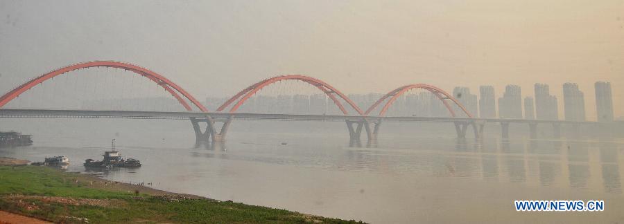 Photo taken on March 7, 2013 shows the Fuyuan Road Bridge across the Xiangjiang River in fog-shrouded Changsha, capital of central China's Hunan Province. (Xinhua/Long Hongtao)