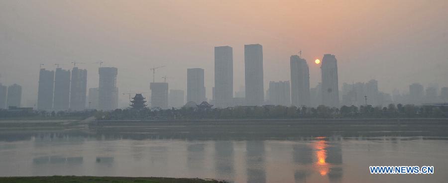 Photo taken on March 7, 2013 shows buildings along the local section of the Xiangjiang River in fog-shrouded Changsha, capital of central China's Hunan Province. (Xinhua/Long Hongtao)