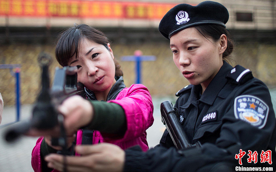 Members of Special Police unit of Huaibei Public Security Bureau in eastern China’s Anhui province demonstrate self-defense skills for local female workers with the hope of improving their awareness and ability of self-protection, March 6, 2013. (Chinanews.com/Han Suyuan) 