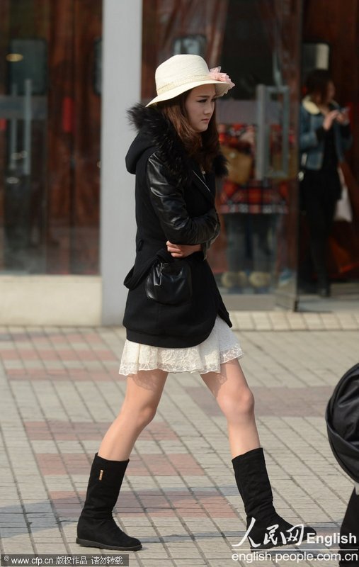 Pedestrian wears spring and even summer clothes on the street of Yangzhou on Mar. 6, 2013. The temperature reached 22 degrees Celsius (Photo/CFP)